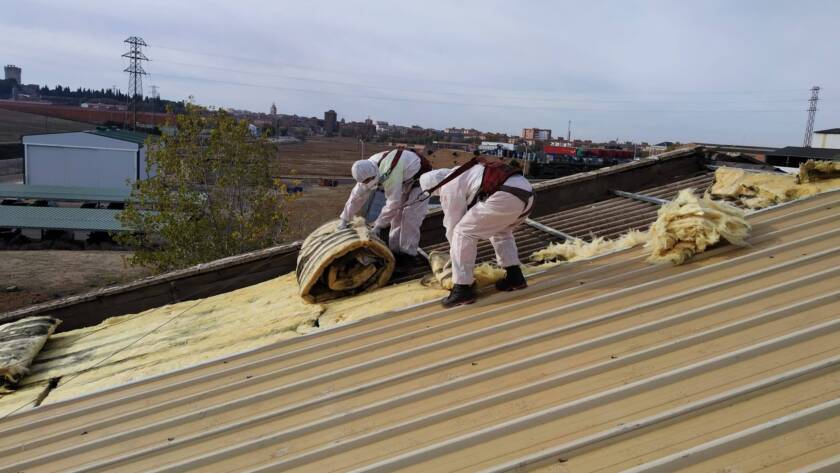 Trabajadores Viso Desamianta con equipo de protección eliminando amianto de techos