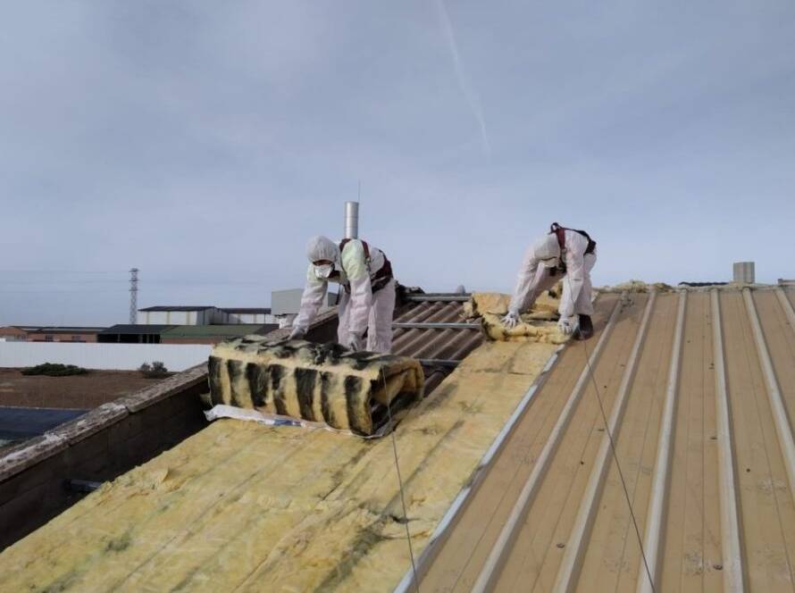 Trabajadores Viso Desamianta con equipo de protección eliminando amianto de techos