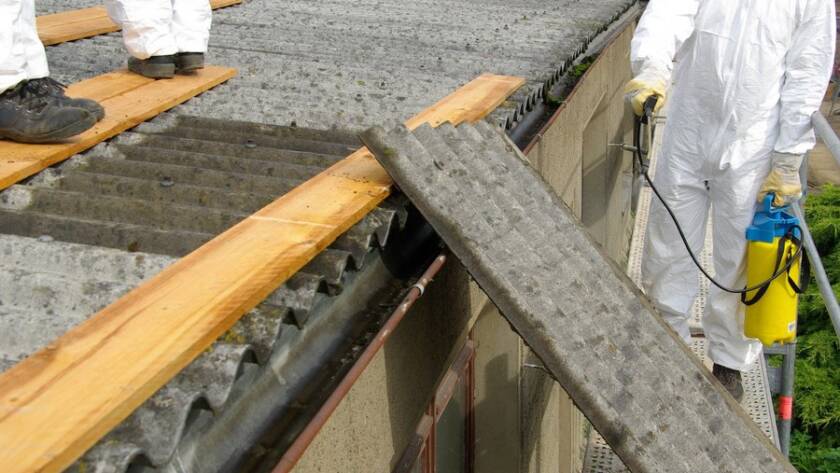 Trabajadores Viso Desamianta eliminando amianto en cubierta desde un andamio