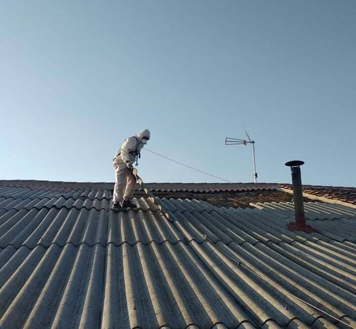 Trabajador Viso Desamianta con equipo de protección retirando amianto de techos de Avilés