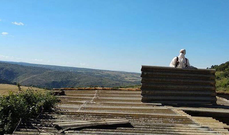 Trabajador Viso Desamianta con equipo de protección retirando amianto de techos