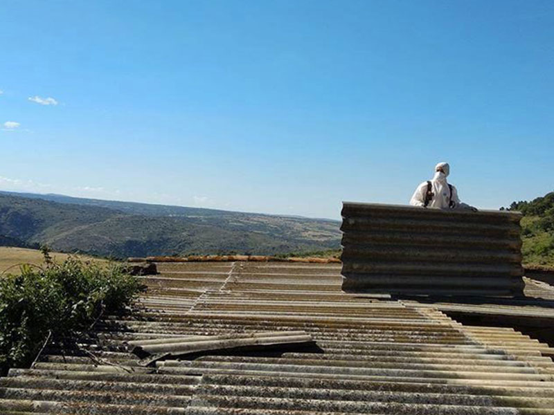 Trabajador Viso Desamianta con equipo de protección retirando amianto de techos