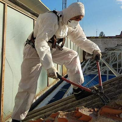 Trabajador Viso Desamianta con equipo de protección eliminando amianto